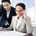 two diverse business women reviewing documents at desk