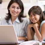 woman working at home with daughter and laptop