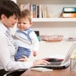 woman working from home with baby on laptop