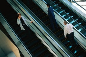 Business People Riding Escalator