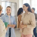Professional women laughing during a meeting after answering funny icebreaker questions