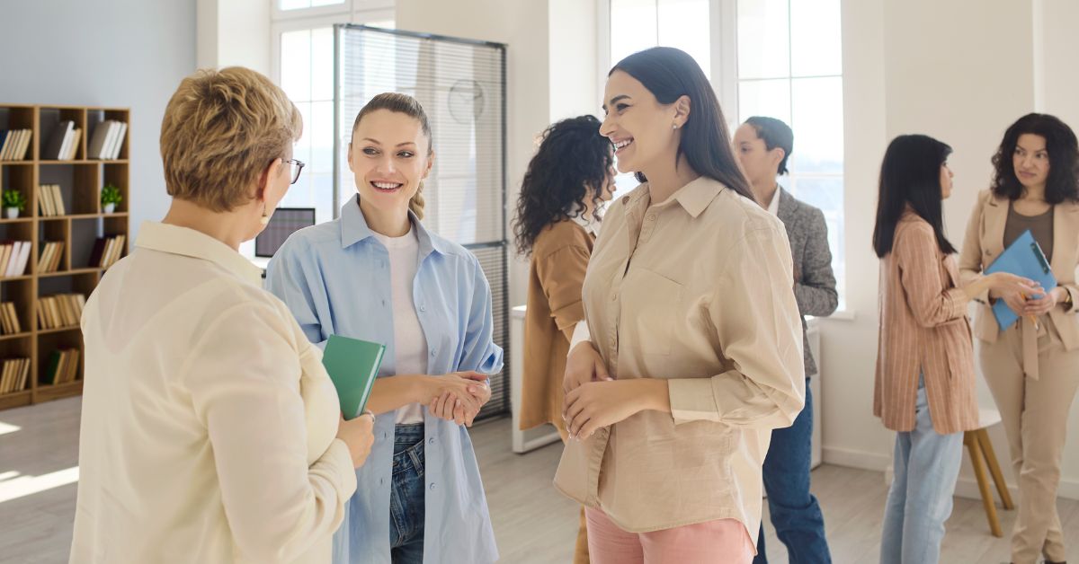 Professional women laughing during a meeting after answering funny icebreaker questions